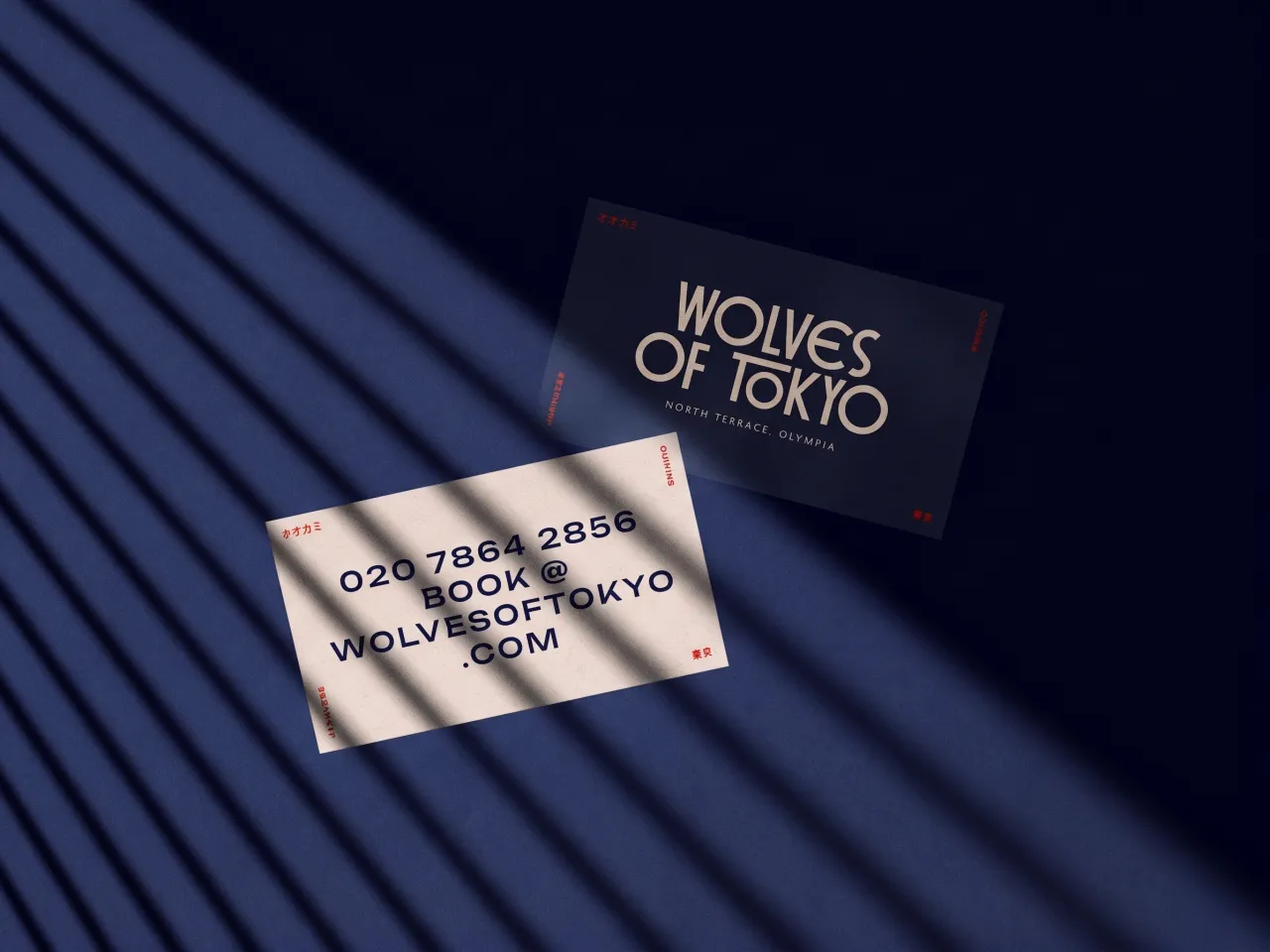 Wolves of Tokyo business cards featuring gold typography on dark navy and cream backgrounds, with contact details and website displayed