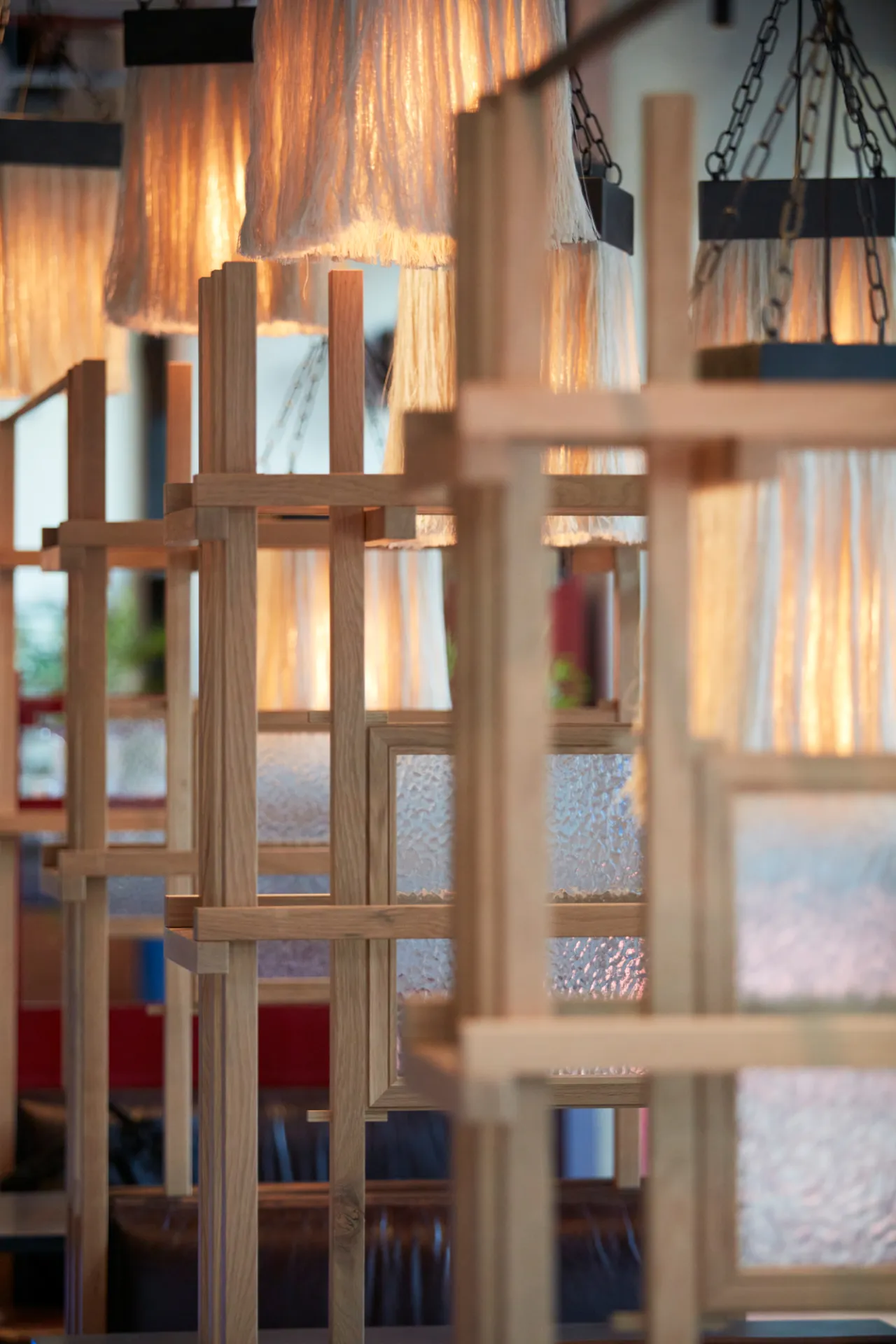 Wooden lattice screens with warm backlit panels create a layered interior at Wolves of Tokyo restaurant in London